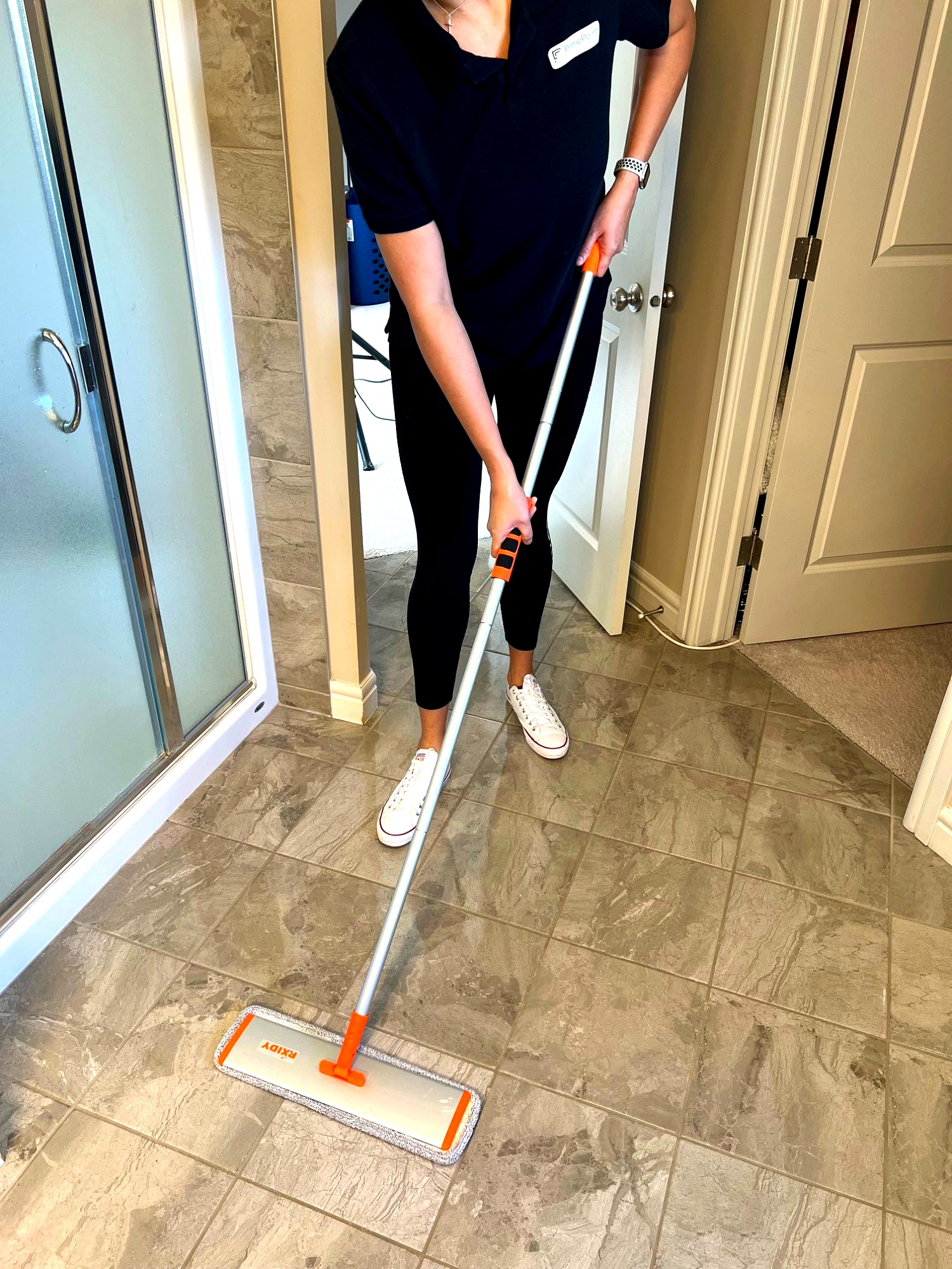PrimePoint team member mopping bathroom floor